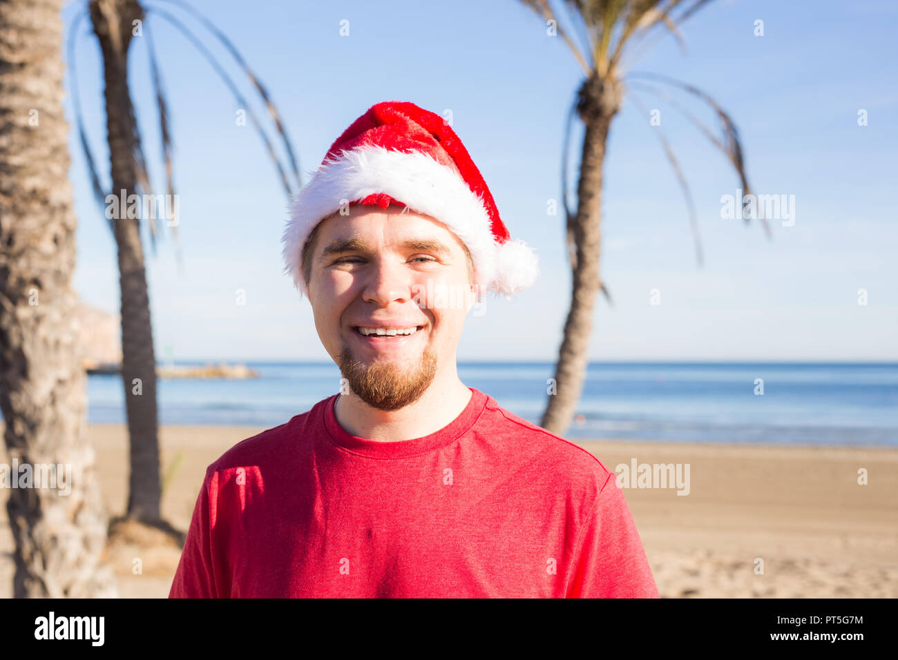 Christmas, people, holidays concept - Young man wearing a Santa hat ...