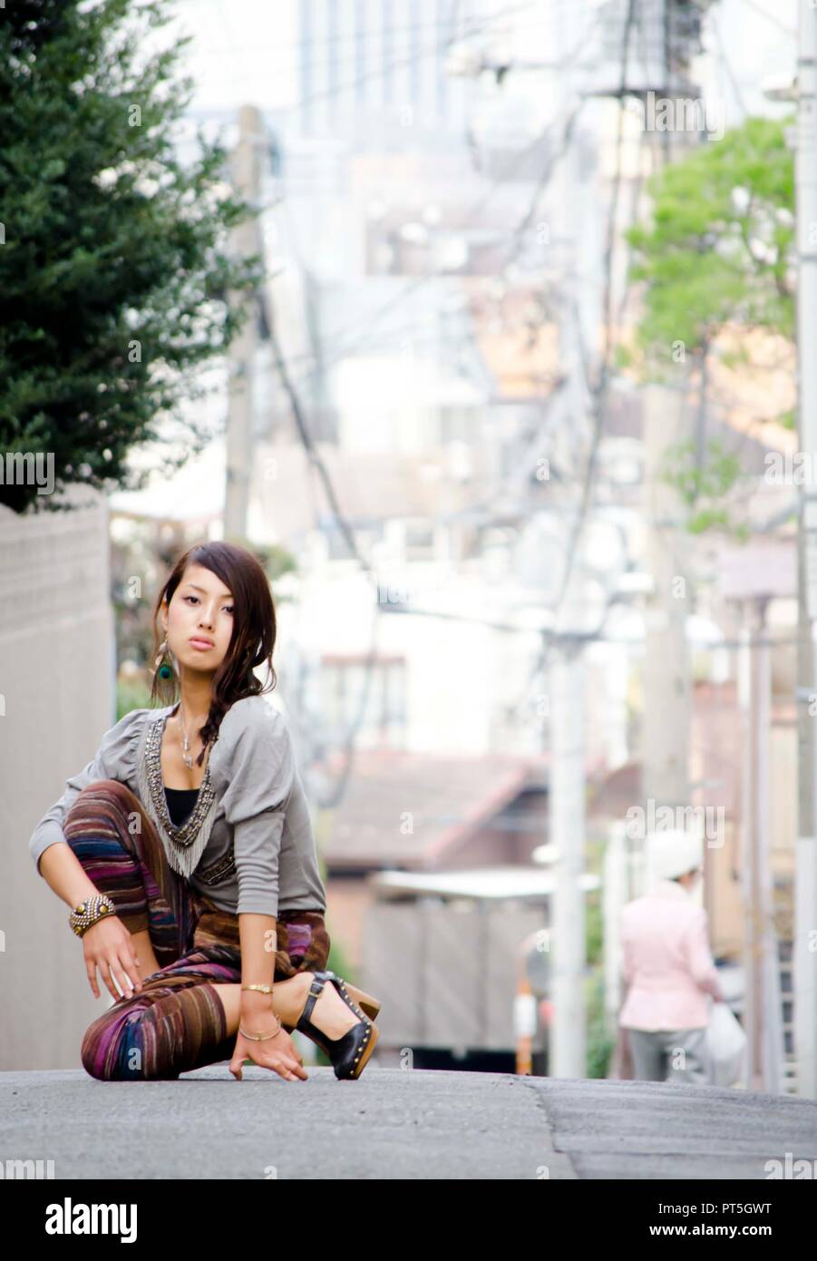 Japanese Girl poses on the street in Nakameguro, Japan. Nakameguro is a town located in the nice area of Tokyo. Stock Photo