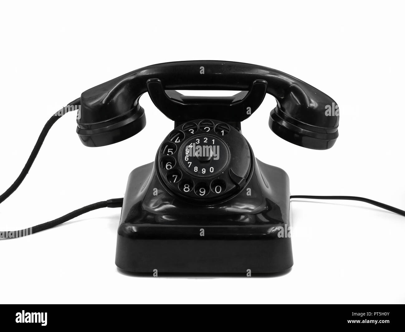 front view of old vintage black rotary dial telephone isolated on white background, retro bakelite phone Stock Photo