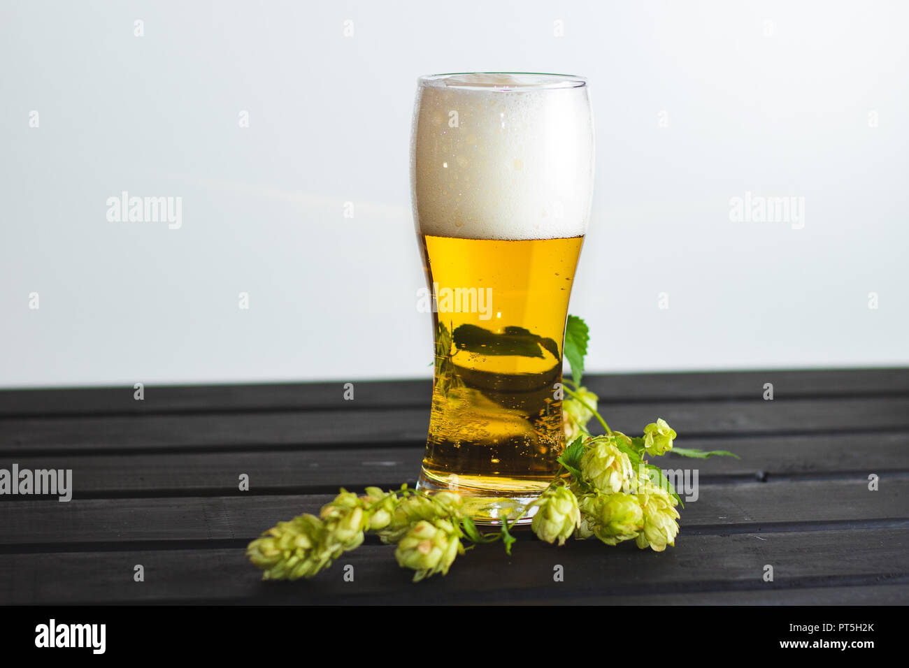 A glass with fresh beer poured with foam. Stock Photo