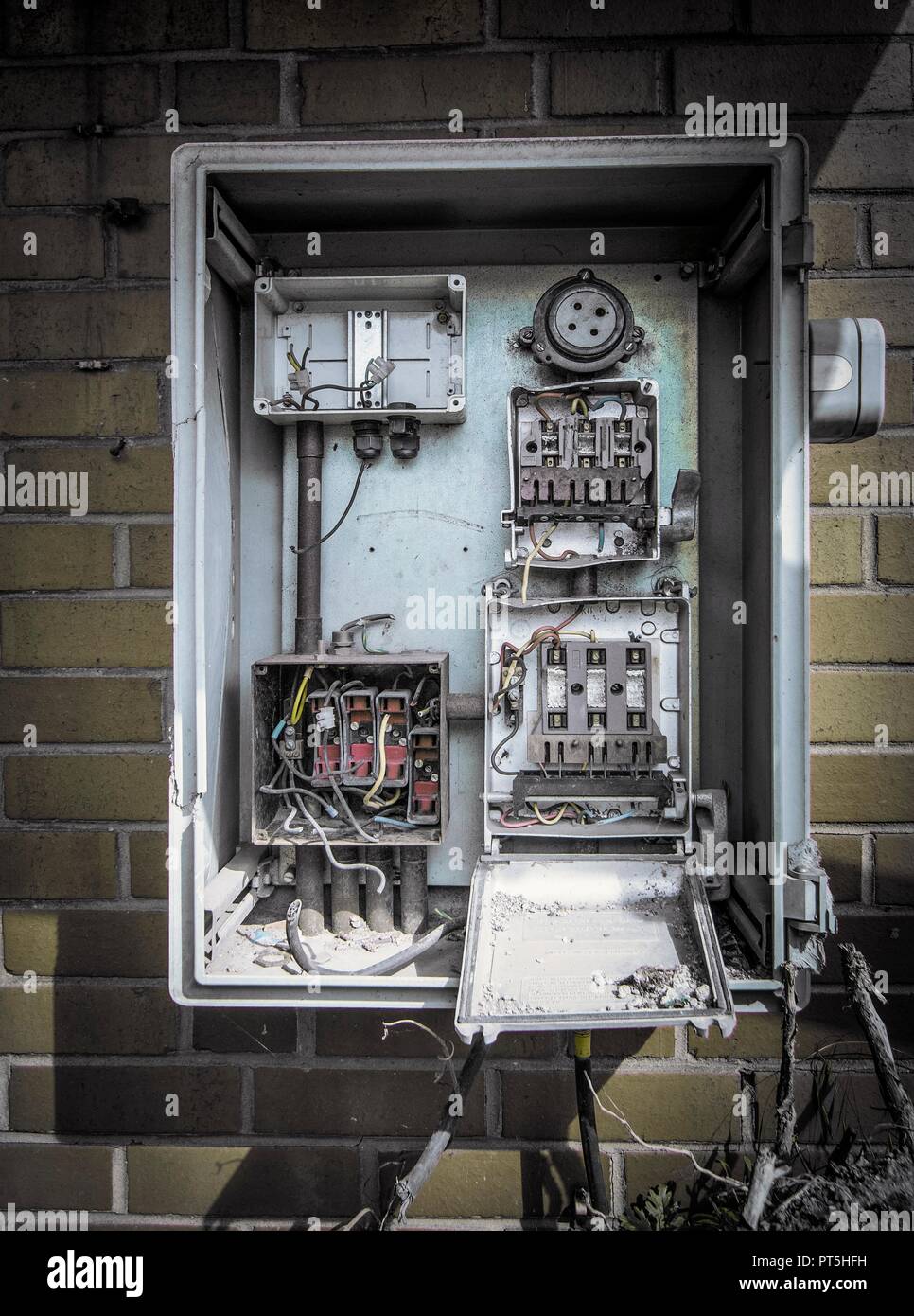 Disused fuse box on wall of abandoned industrial building. Stock Photo