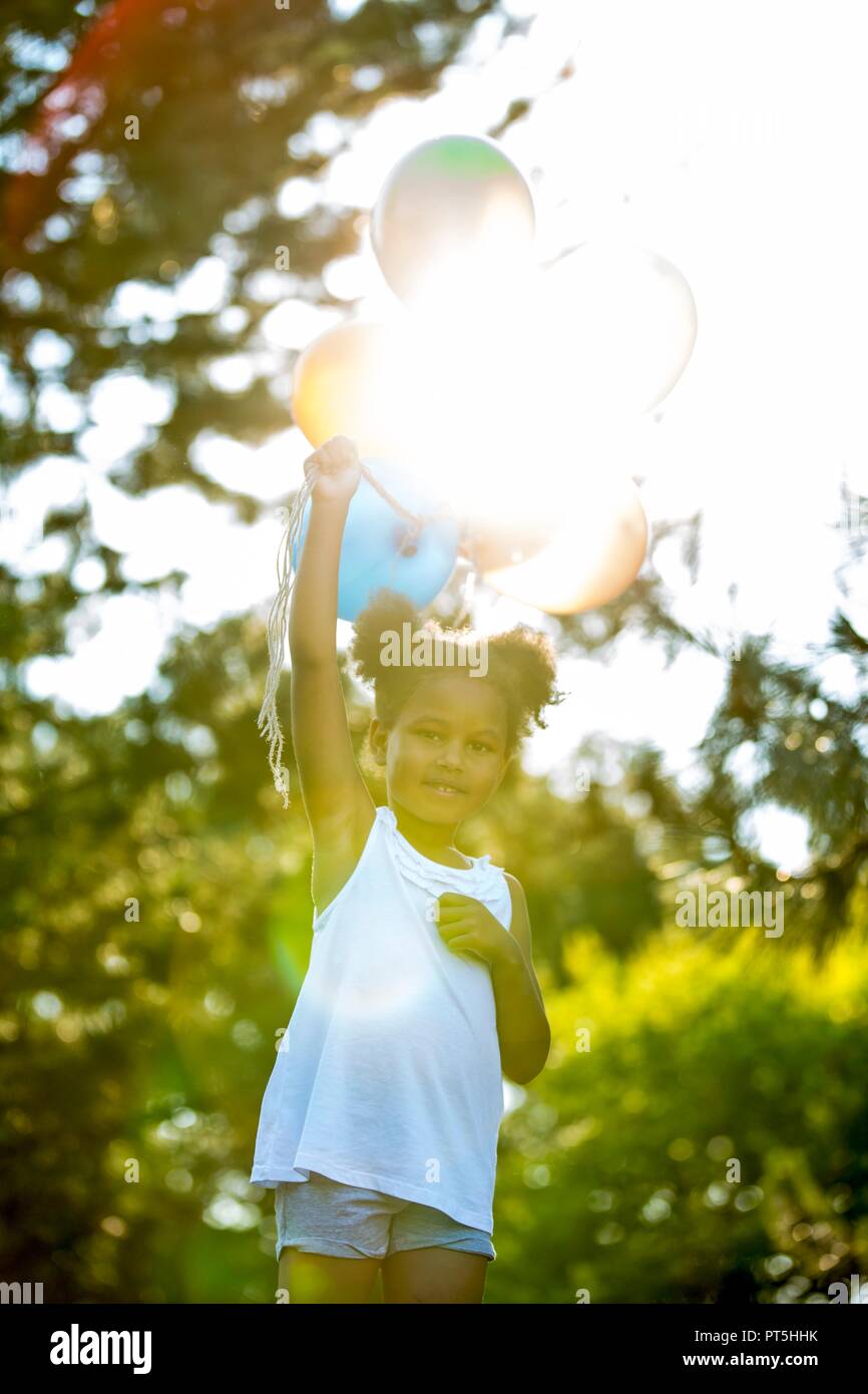 Black girl holding bunch balloons hi-res stock photography and images ...