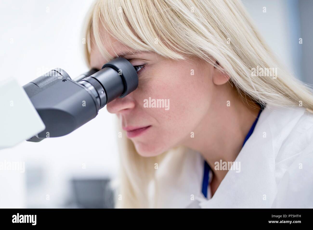 Female laboratory technician using microscope in the lab. Stock Photo