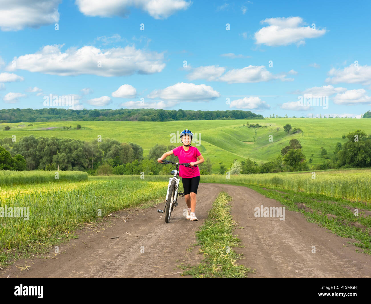 girl on a bicycle in rural landscape Stock Photo