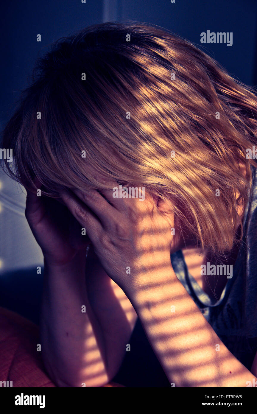 woman holding her head in despair, solitude, sadness and depression concept Stock Photo