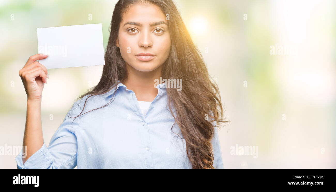 young arab woman holding blank card over isolated background