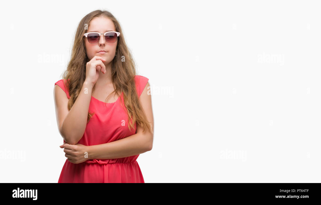 Young blonde woman wearing pink sunglasses serious face thinking about question, very confused idea Stock Photo