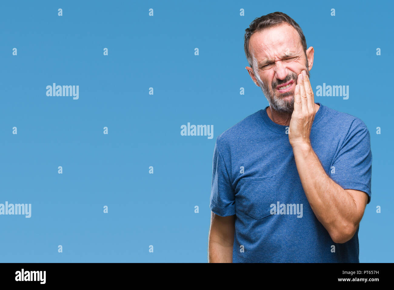 Middle age hoary senior man over isolated background touching mouth with hand with painful expression because of toothache or dental illness on teeth. Stock Photo