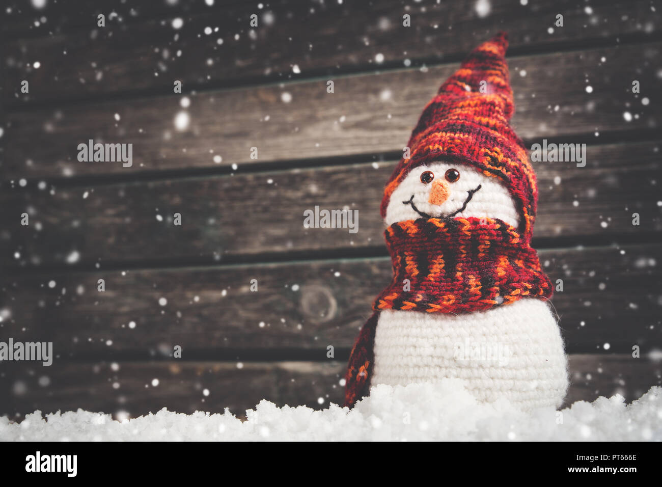 little snowmans on soft snow on wooden background Stock Photo