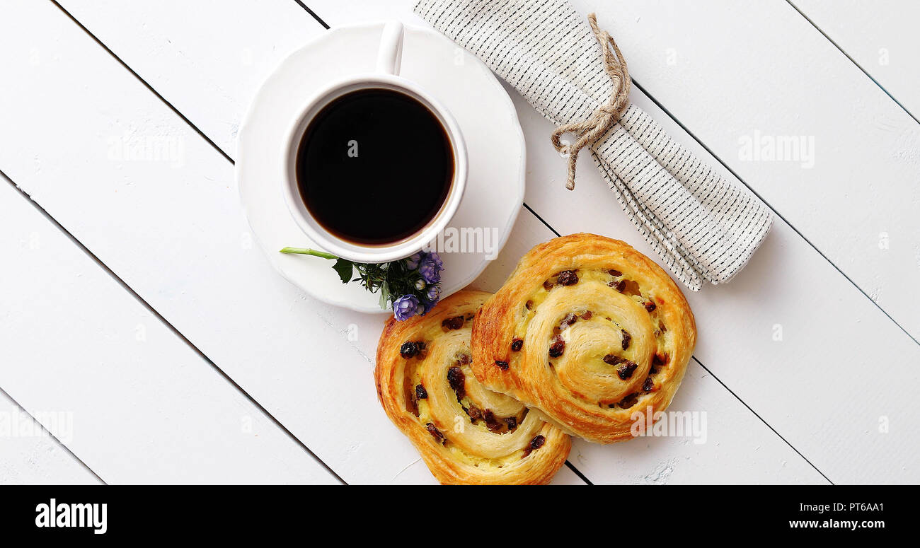 https://c8.alamy.com/comp/PT6AA1/delicious-pastry-with-raisins-and-a-cup-of-coffee-top-view-PT6AA1.jpg