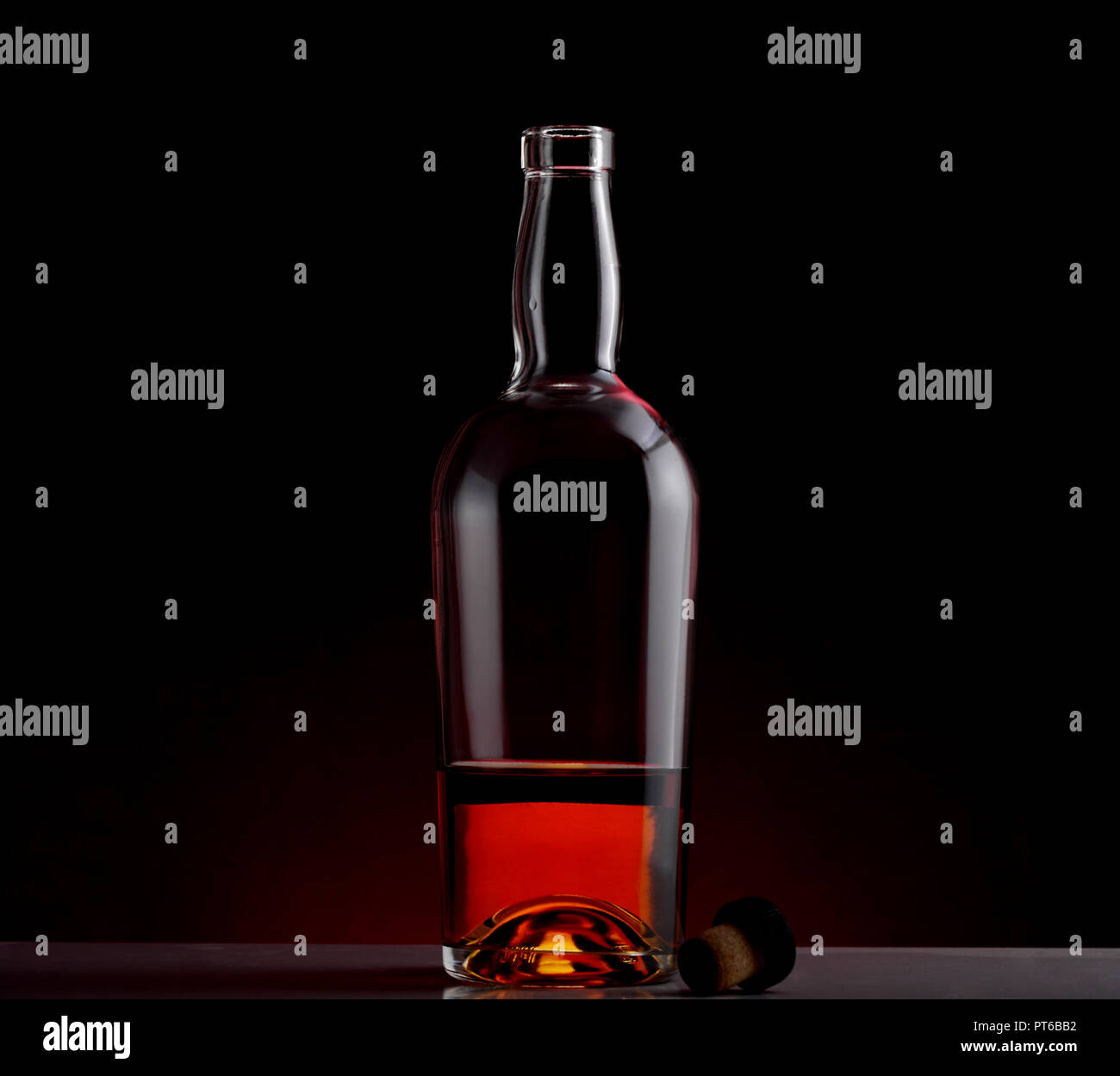 A bottle of whiskey opened with cork lid and black clean background Stock Photo
