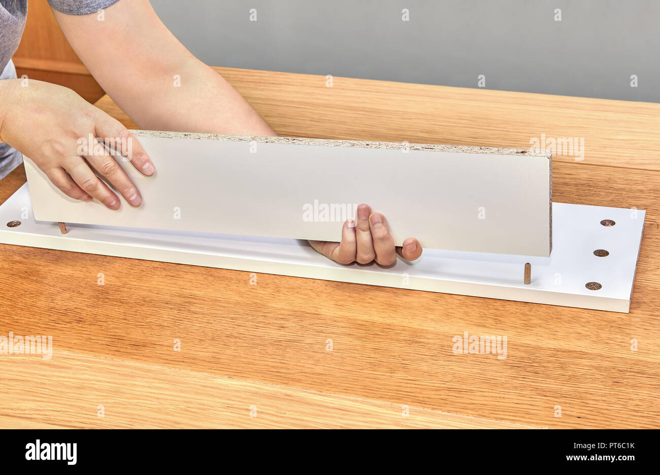 Furniture Assembler Connects The Drawer Parts Using Wooden Pins
