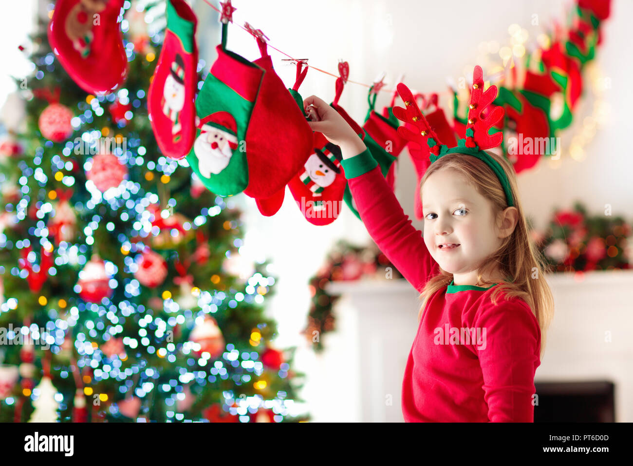 Kids opening Christmas presents. Child searching for candy and gifts in advent calendar on winter morning. Decorated Christmas tree for family with ch Stock Photo