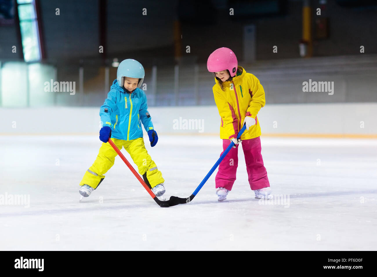 Children play ice hockey on indoor rink. Healthy winter sport for kids