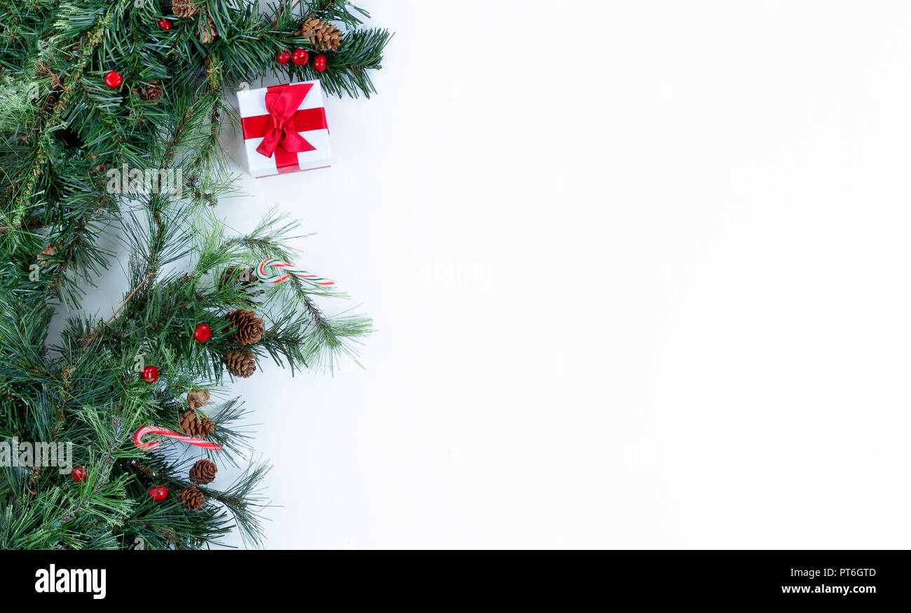 Christmas tree evergreen branches and decorations on left border of a ...