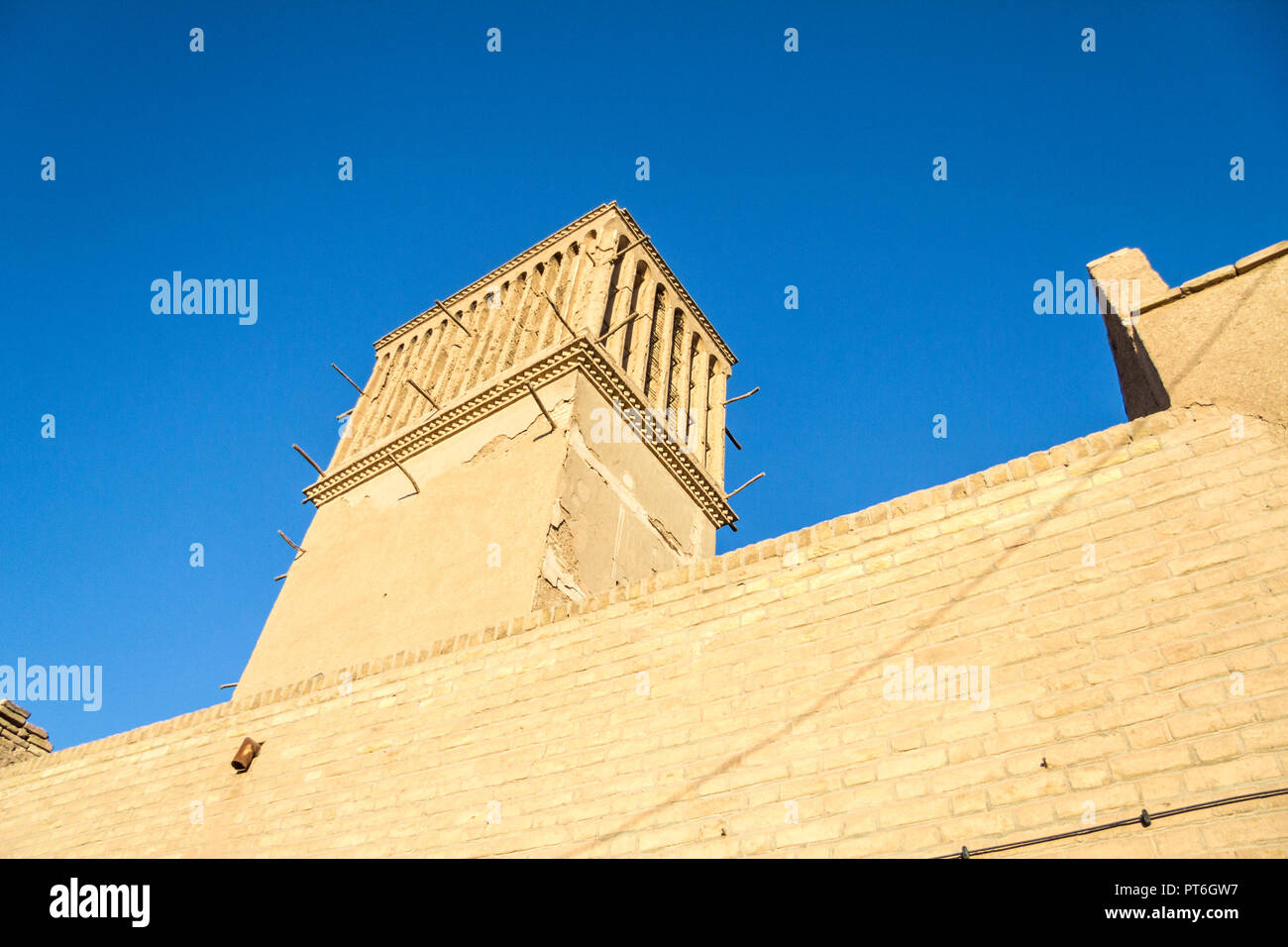 typical Windtower made of clay taken in the streets of Yazd, iran. These towers, aimed at cooling down buildings in the desert, are an icon of the Per Stock Photo