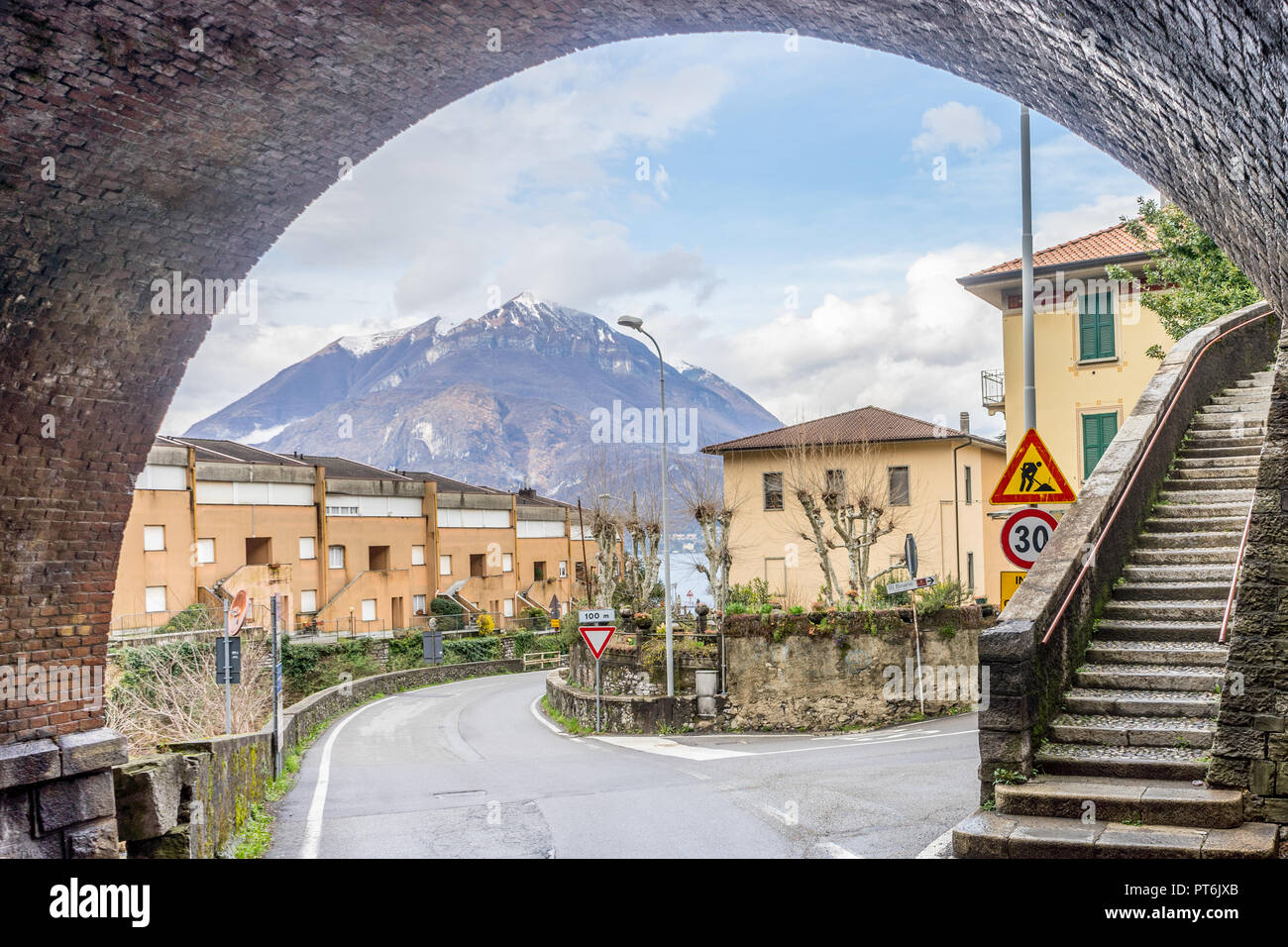 Italy, Varenna, Lake Como, snow capped maountain viewed under an arch