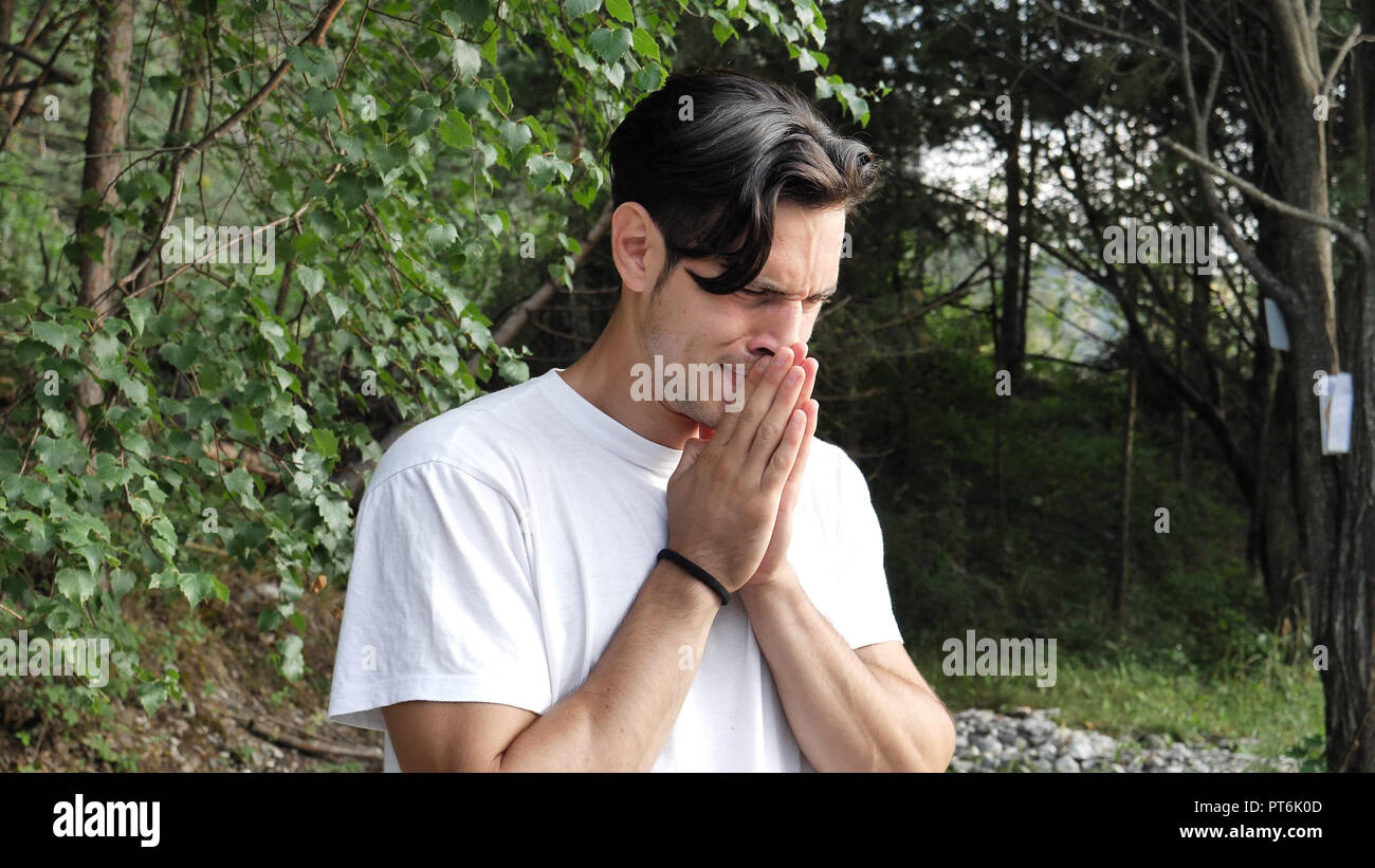 Young upset,sad, worried man in nature, crying Stock Photo