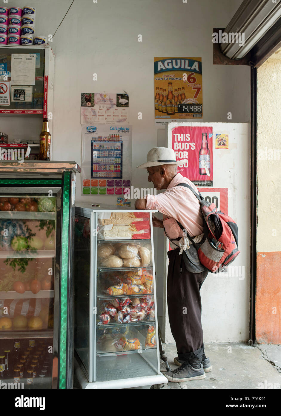 Unidentified Colombian man having a cold drink in a corner shop to escape the daytime hot temperatures (around 32 C). Santa Marta, Colombia. Sep 2018 Stock Photo