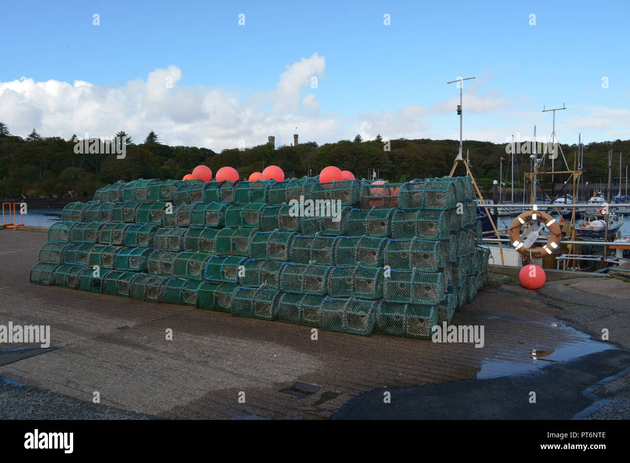 Fish pots traps stacked neatly with buoys on top at Stornoway harbour pier Western Isles capital of Lewis and Harris Scotland UK United Kingdom Stock Photo