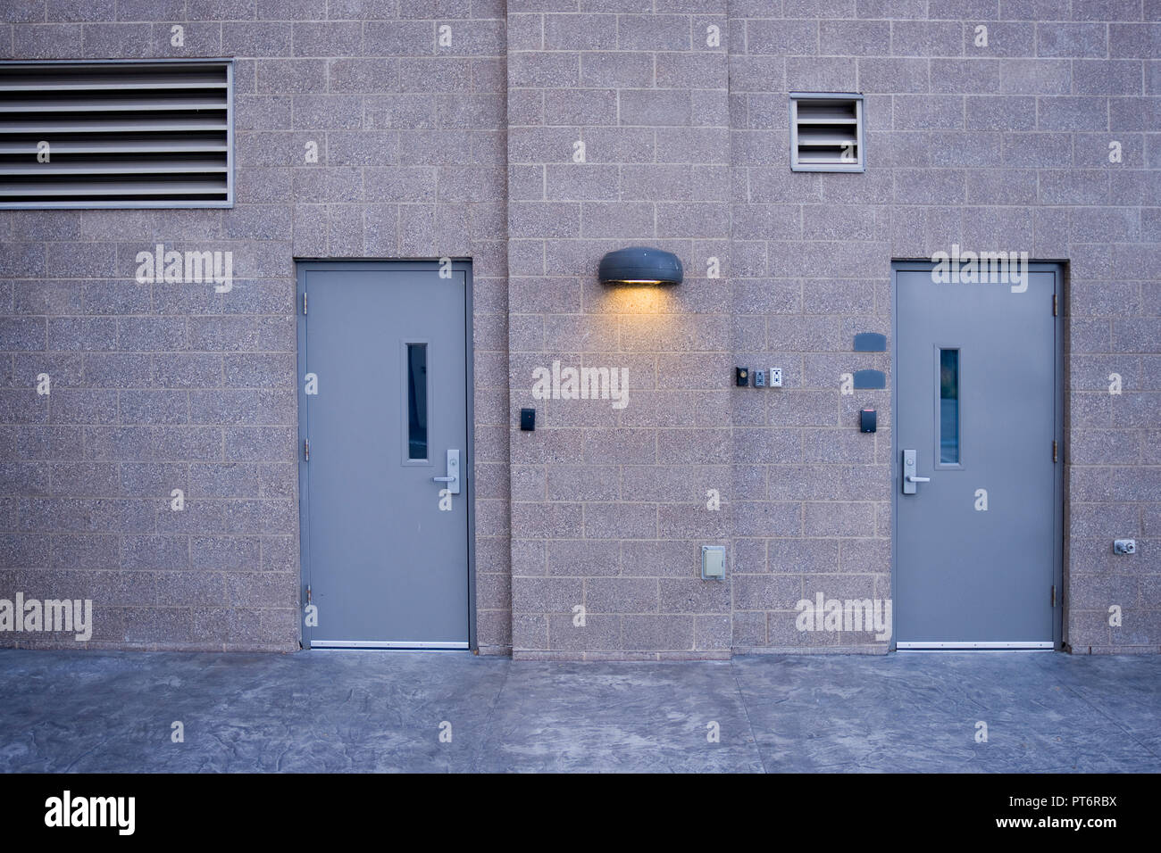 Industrial facility with secure doors, vents and security light. Stock Photo