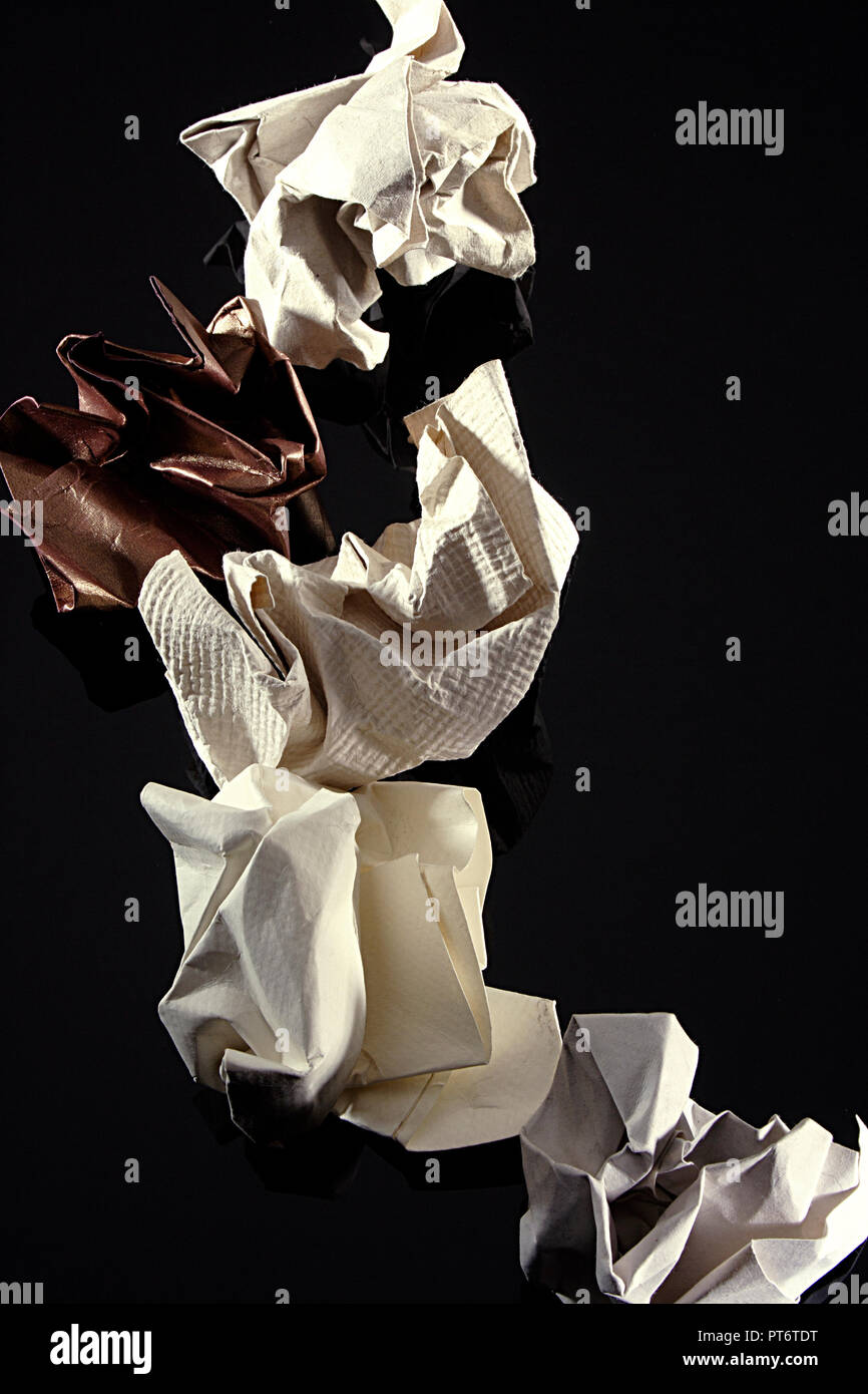 STILL LIFE OF CRUMPLED PAPER ON A BLACK BACKGROUND Stock Photo