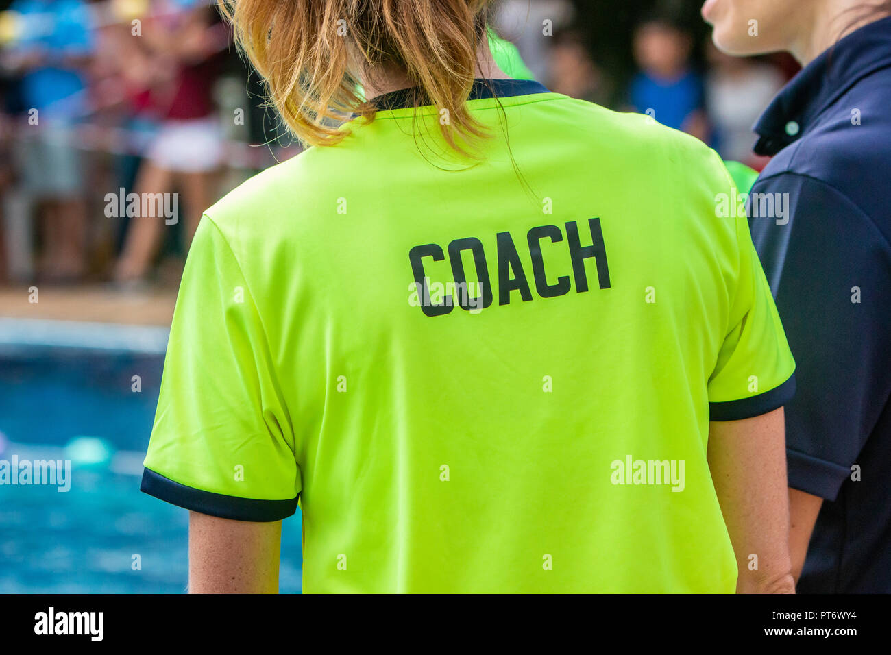 Back view of female sport coach wearing COACH shirt Stock Photo