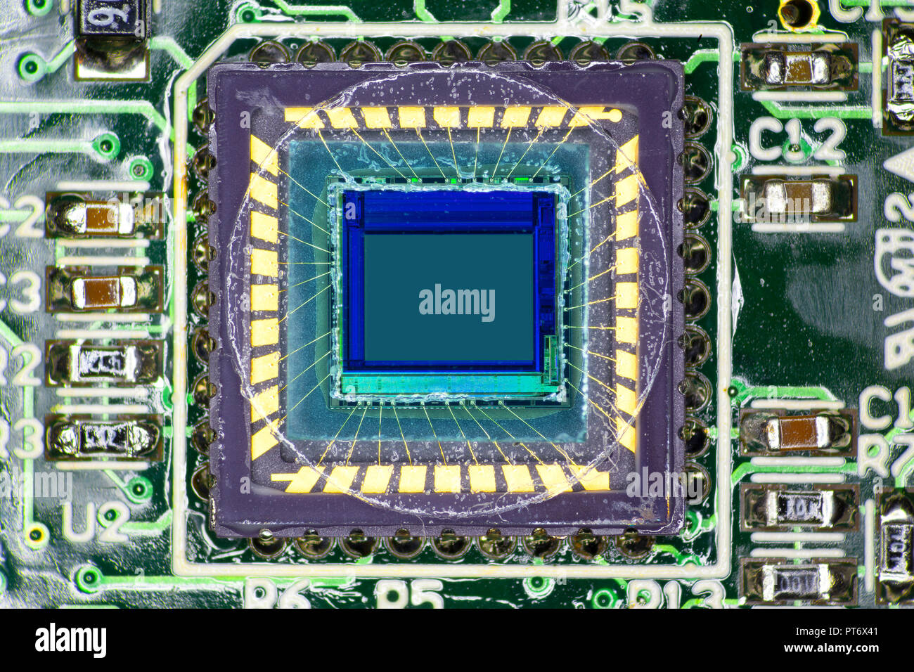 High macro view of a CMOS camera sensor (webcam) showing gold wire contacts and surrounding circuitry. Stock Photo