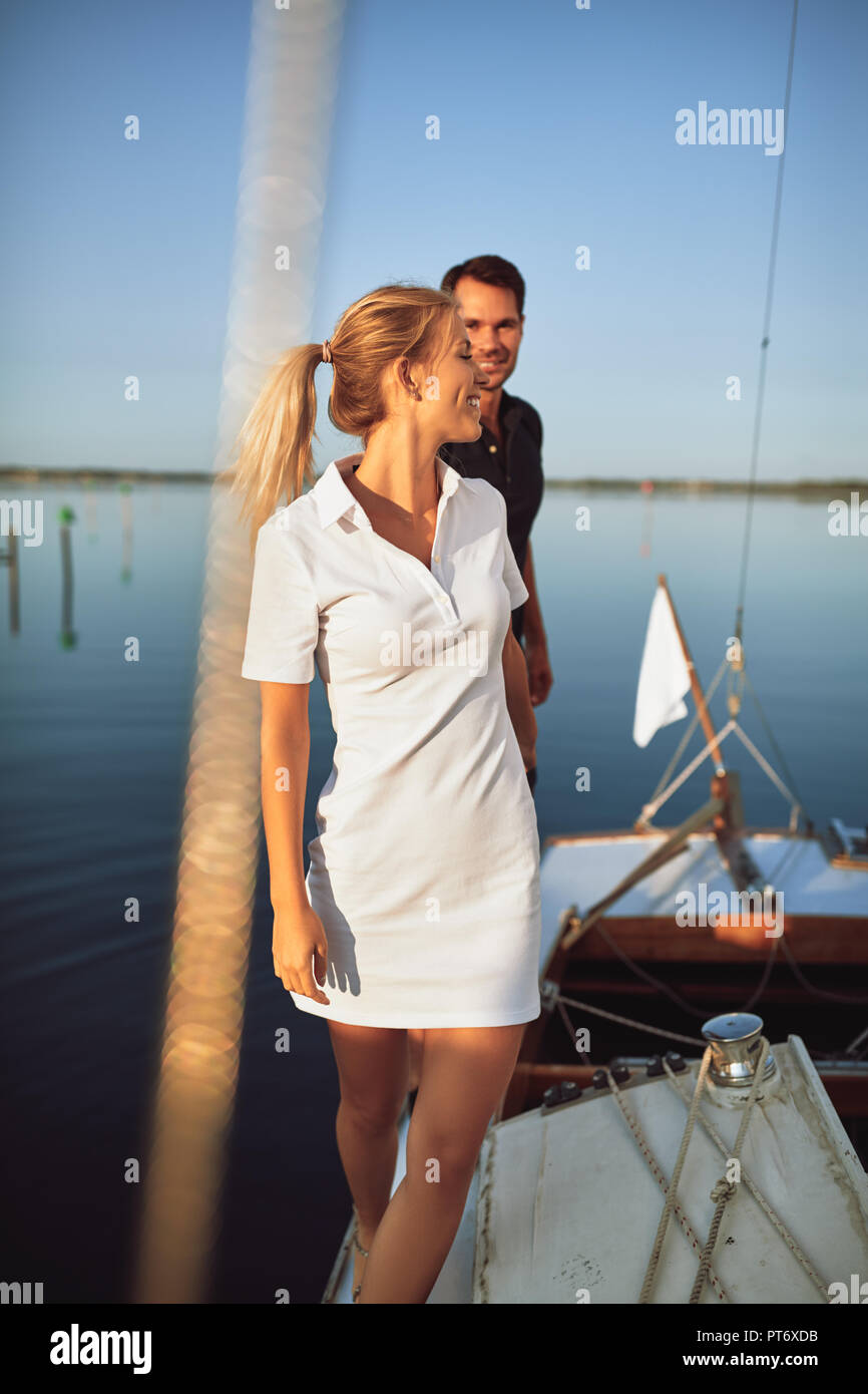 Young woman leading her husband by the hand along the deck of a boat while enjoying the day sailing together Stock Photo