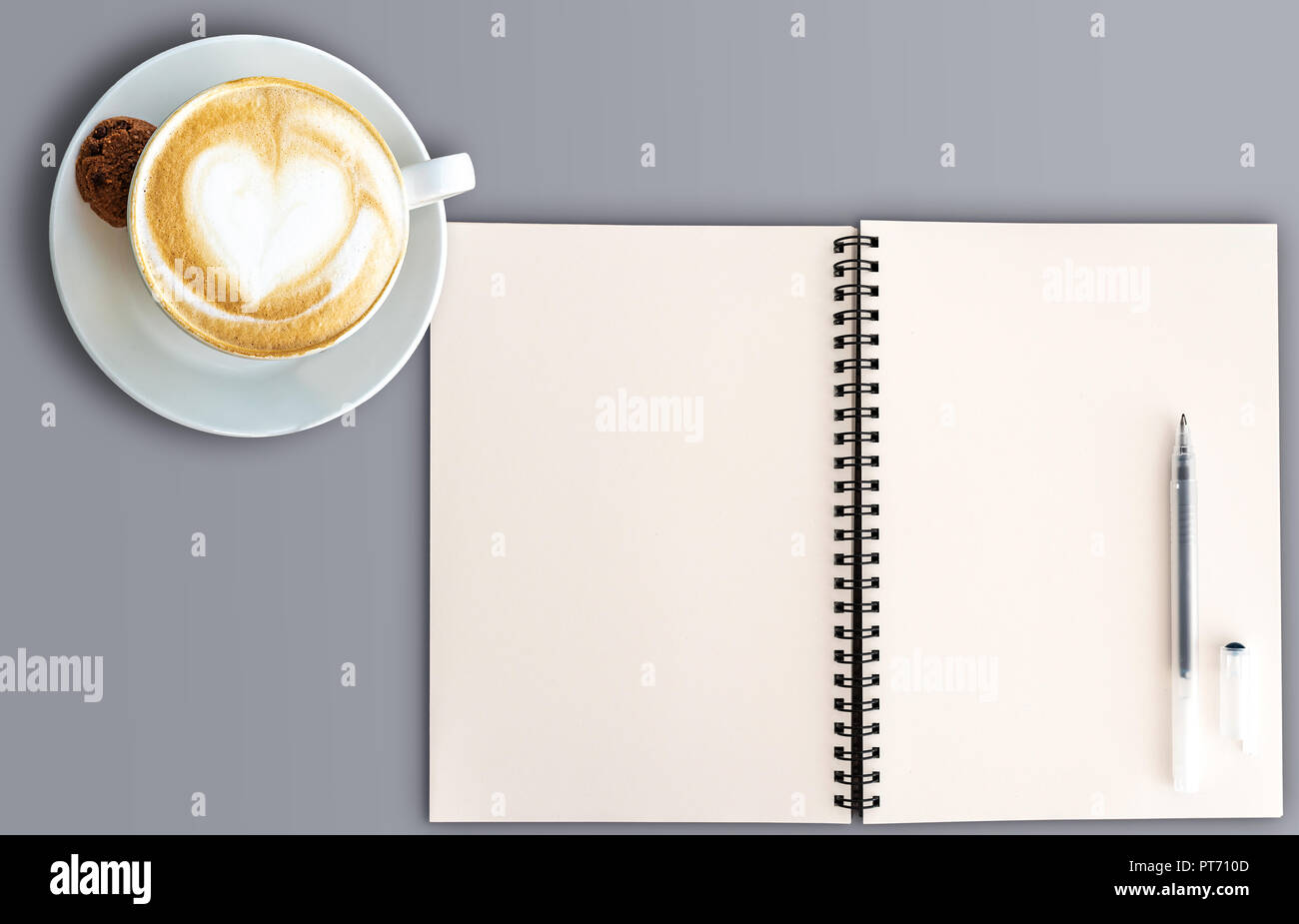 top view of open spral note pad and cup of cappuccino  Stock Photo