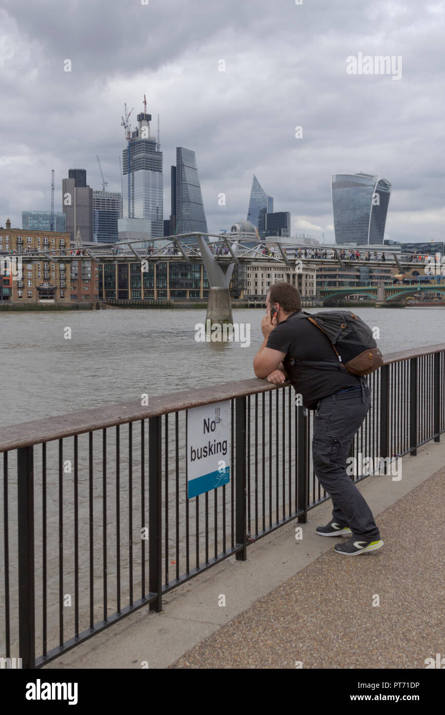London Millennium Footbridge, Thames Embankment, London, UK. 08th September 2018. UK. Tourist making a phone call by the River Thames. Stock Photo