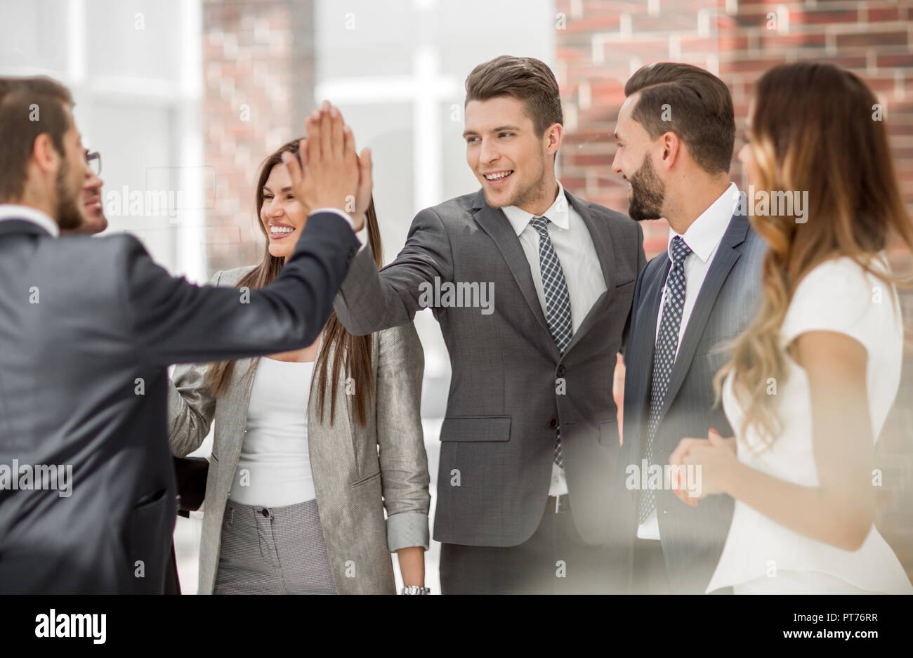 smiling business colleagues give each other a high five Stock Photo - Alamy