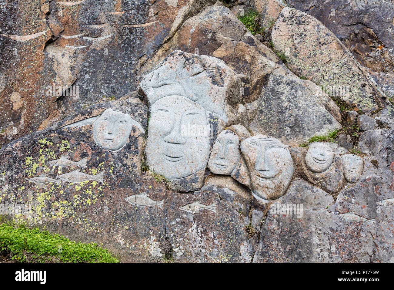 Faces on the rock face as part of the Stone & Man Sculpture, Qaqortoq, Greenland Stock Photo