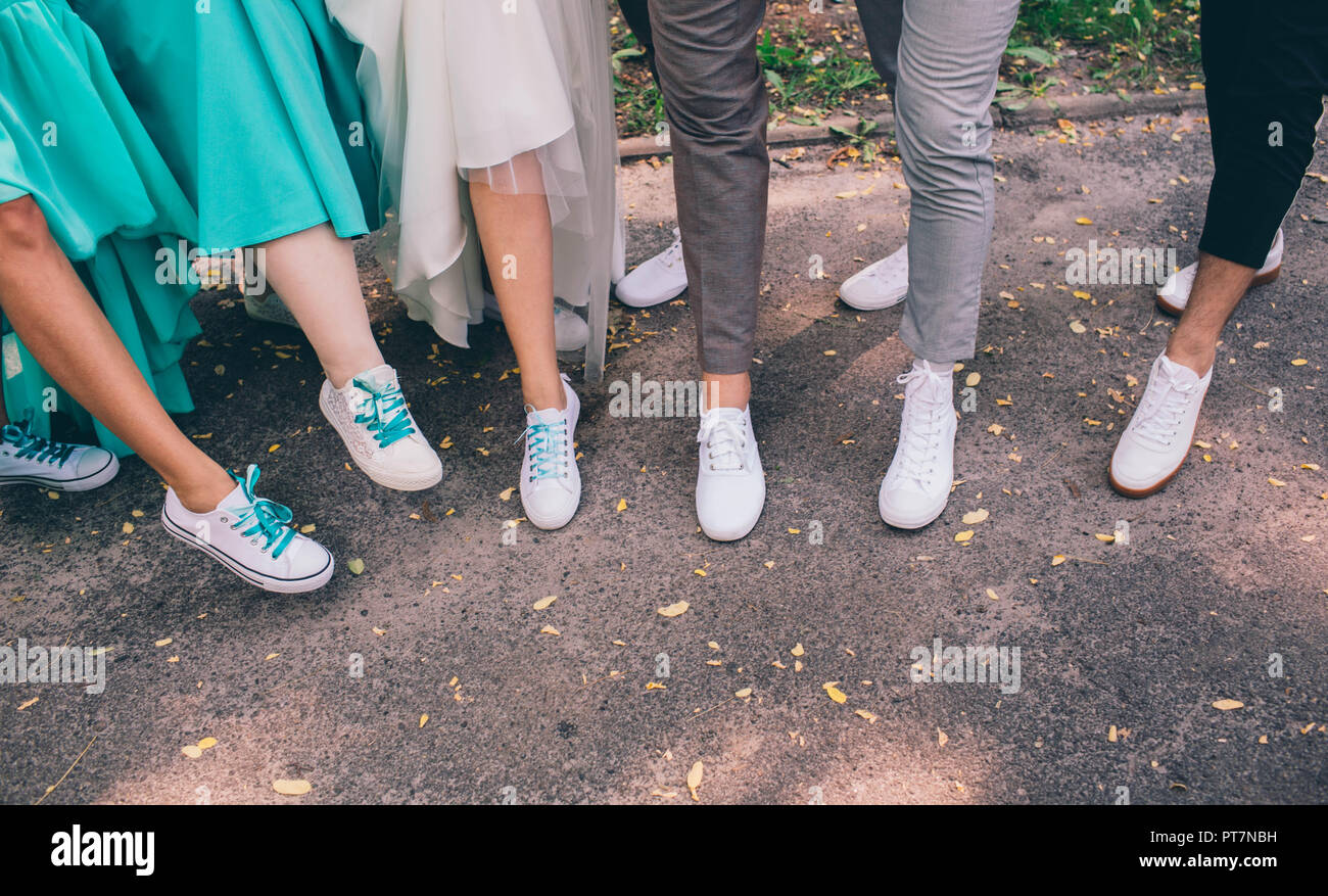 croppedhuman legs wearing white sneakers. Wedding in sneakers Stock Photo