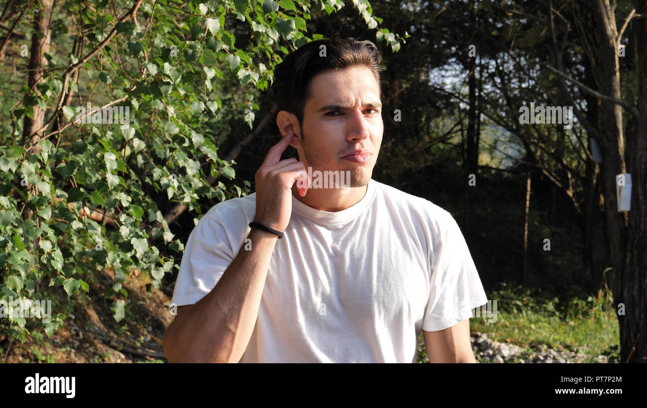 Young man can't hear you, in nature Stock Photo
