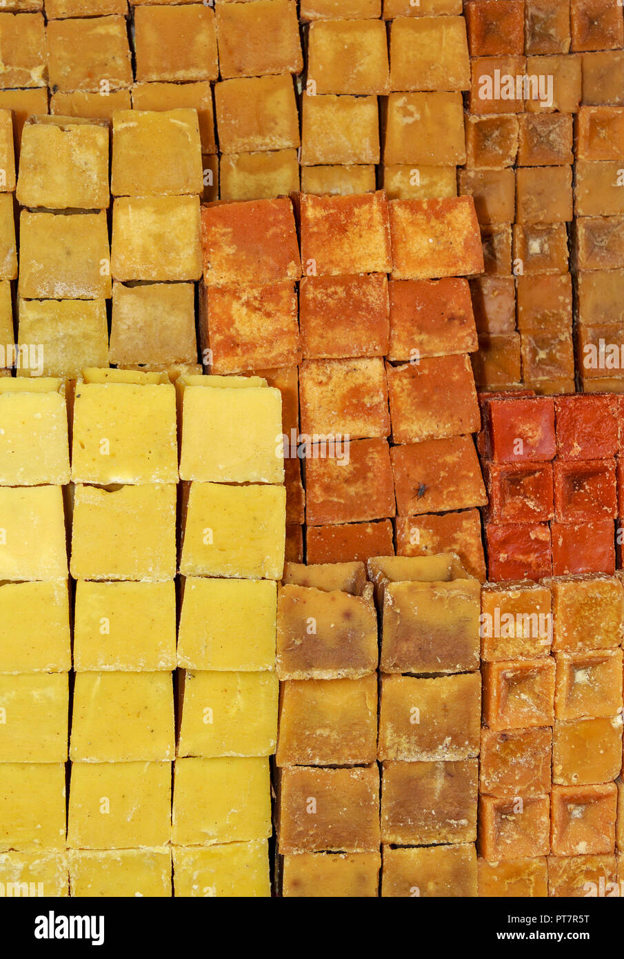 JAGGERY CANE SUGAR BLOCKS STACKED ON A STALL IN INDIA Stock Photo