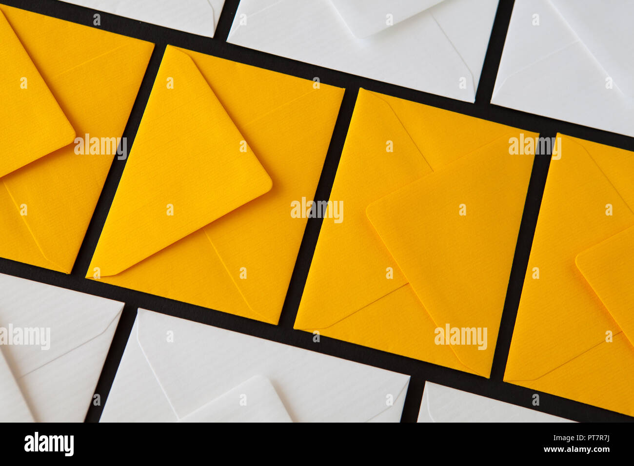 Composition with white and yellow, envelopes on the table. Different colored envelopes on the table. Stock Photo