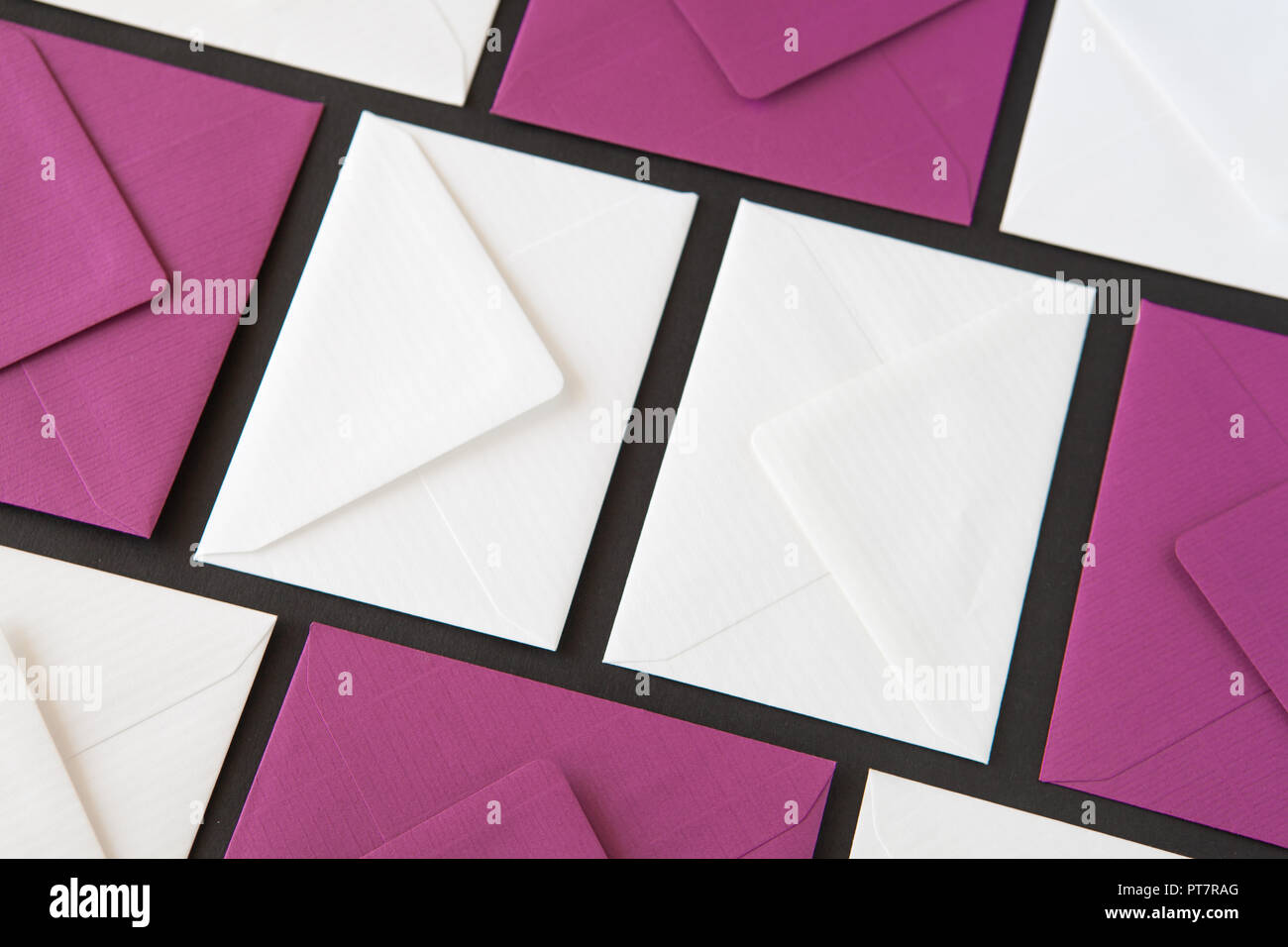 Composition with white and purple envelopes on the table. Different colored envelopes on the table. Stock Photo