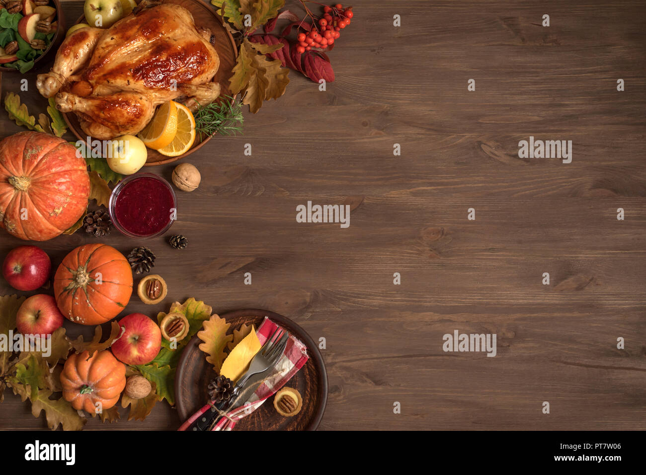 Thanksgiving dinner background with turkey, fall leaves, seasonal autumnal decor and table setting, top view, copy space. Stock Photo