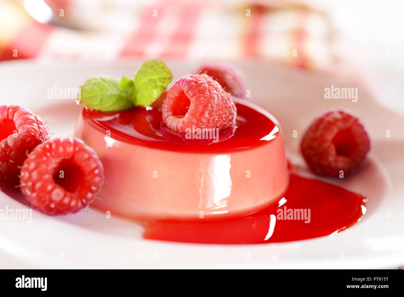 Panna cotta dessert with frsh raspberries and mint leaves on top Stock Photo