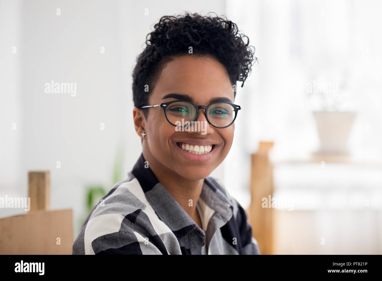 African woman sitting at desk in office looking at camera Stock Photo ...