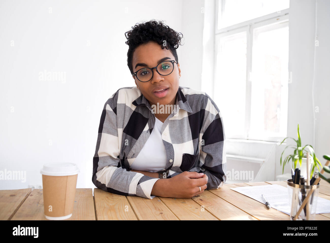 Attractive young black woman sitting talking looking at camera Stock Photo