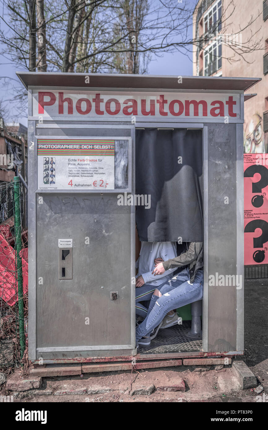 A couple link arms in a Photoautomat, a retro black & white photographic booth, on the east side of Berlin, Germany. Stock Photo