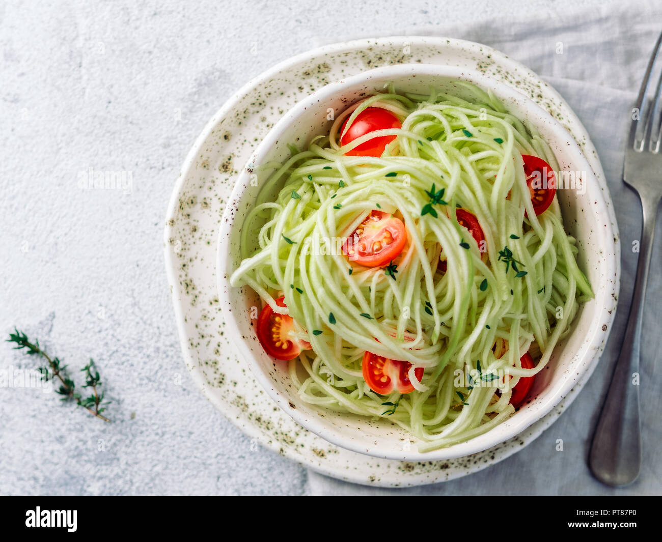 Zucchini noodles salad with cherry tomatoes. Vegetable noodles - green zoodles or courgette spaghetti salad ready-to-eat. Clean eating, raw vegetarian Stock Photo