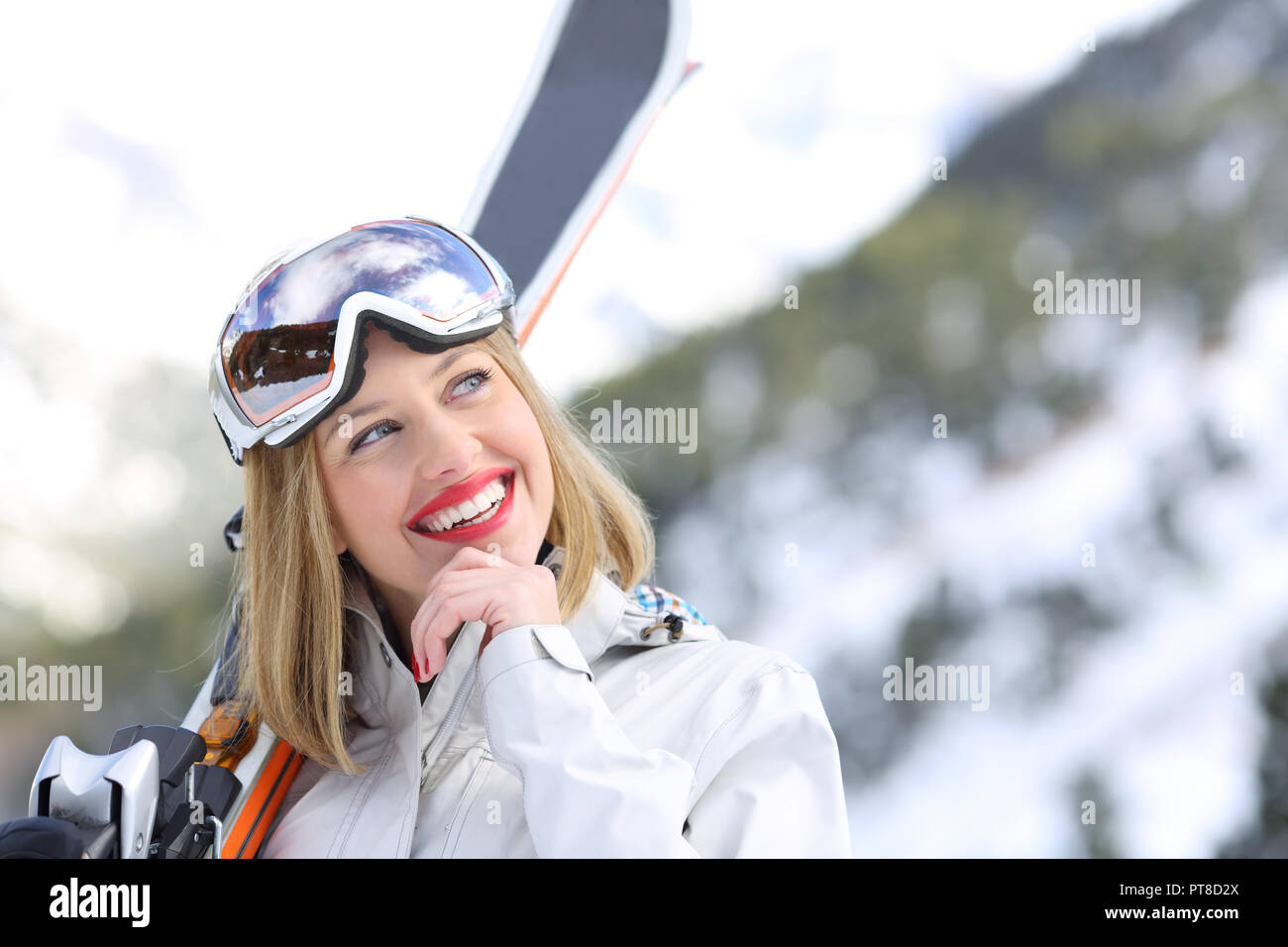 Happy skier thinking looking at side in winter holiday in the mountain Stock Photo