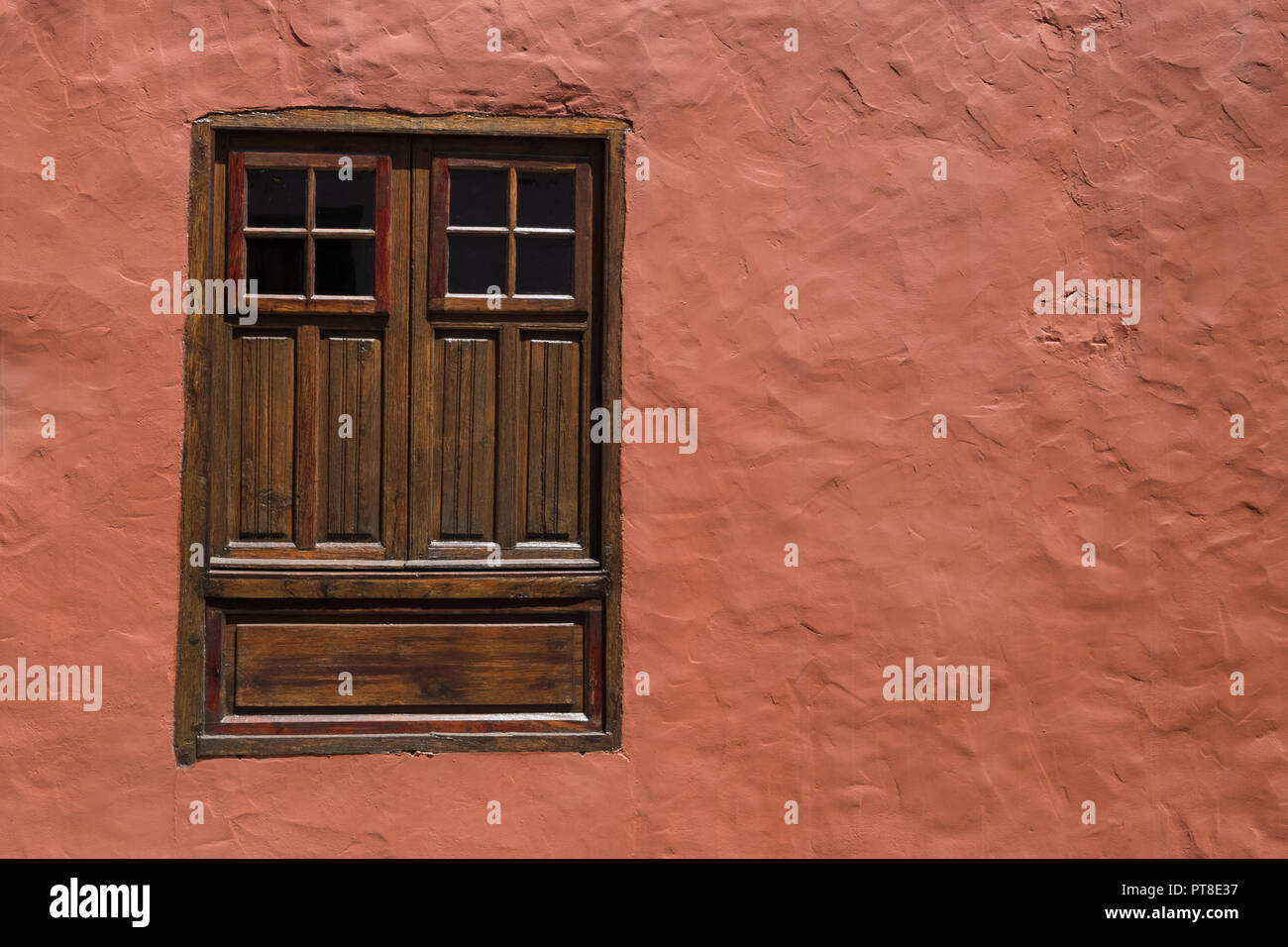 house facade and window with closed wooden shutters Stock Photo