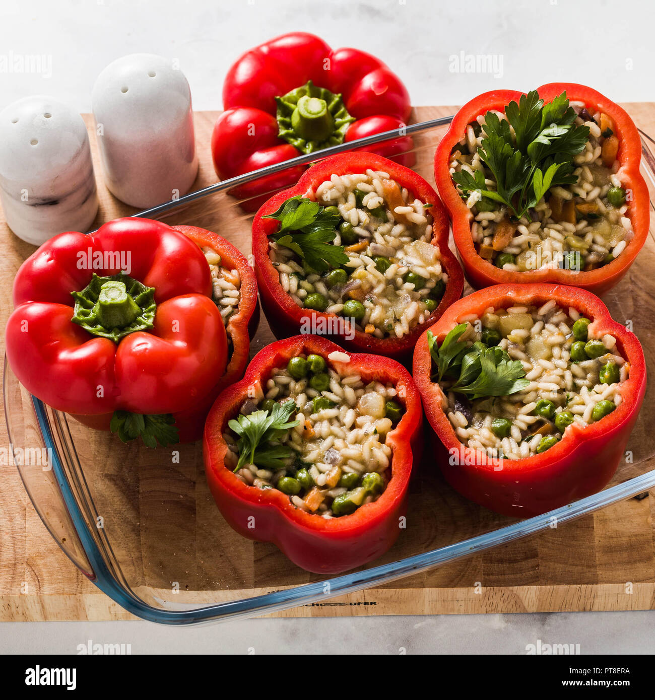 Stuffed peppers in a glass baking dish, ready for baking in the oven