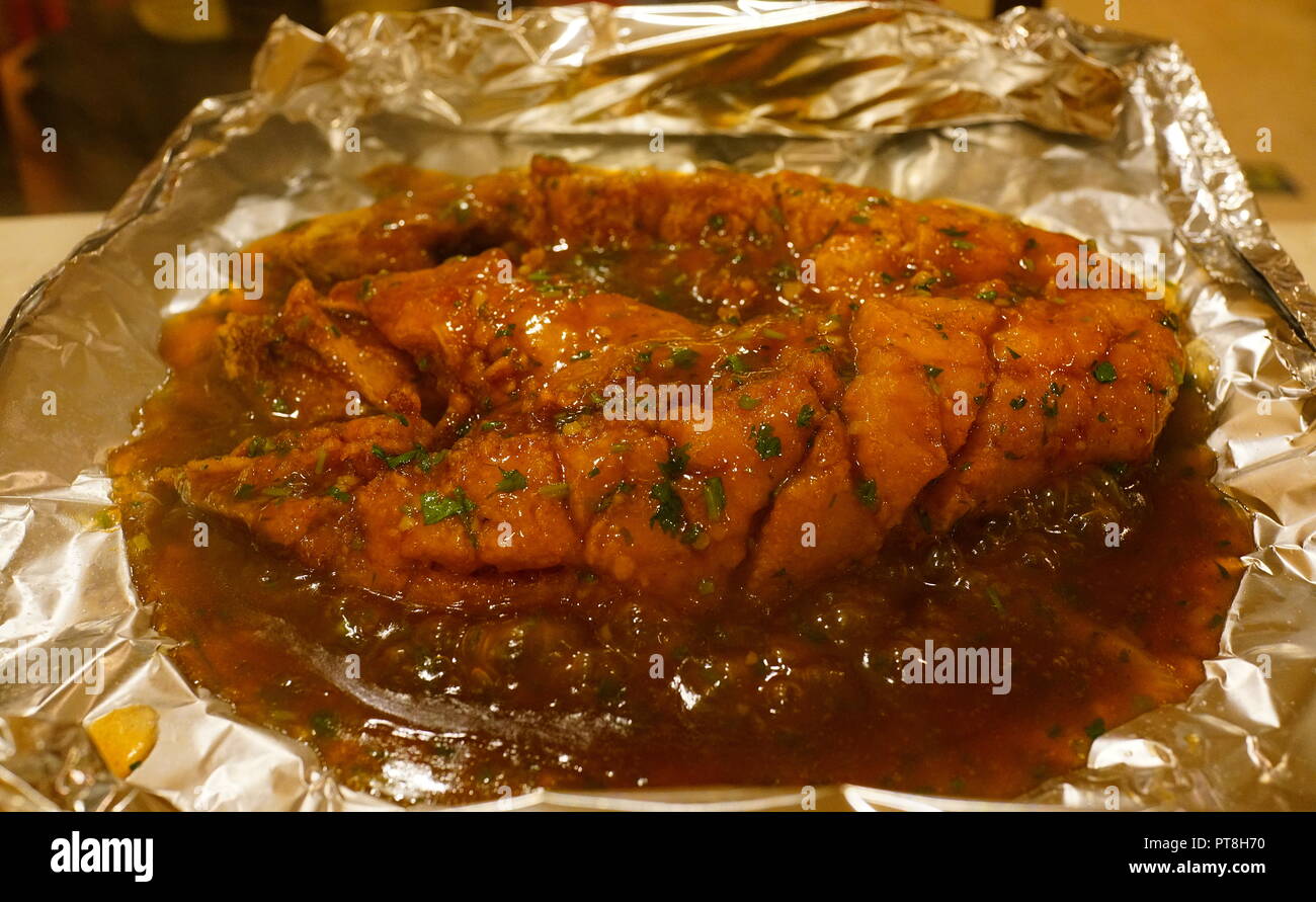 Chinese food striped bass cooked in tin foil packet Stock Photo