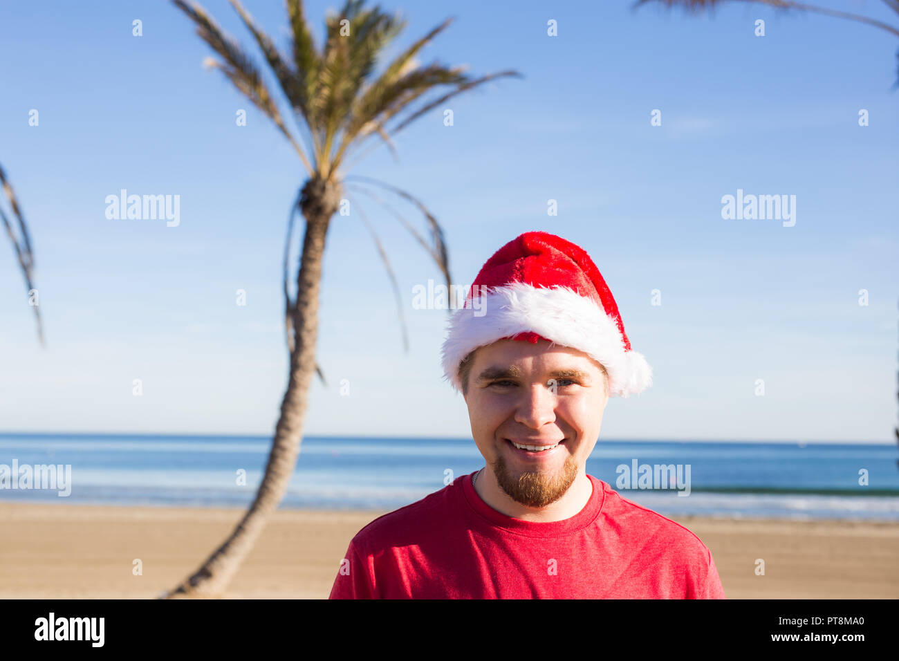 Christmas, people, holidays concept - Young man wearing a Santa hat ...