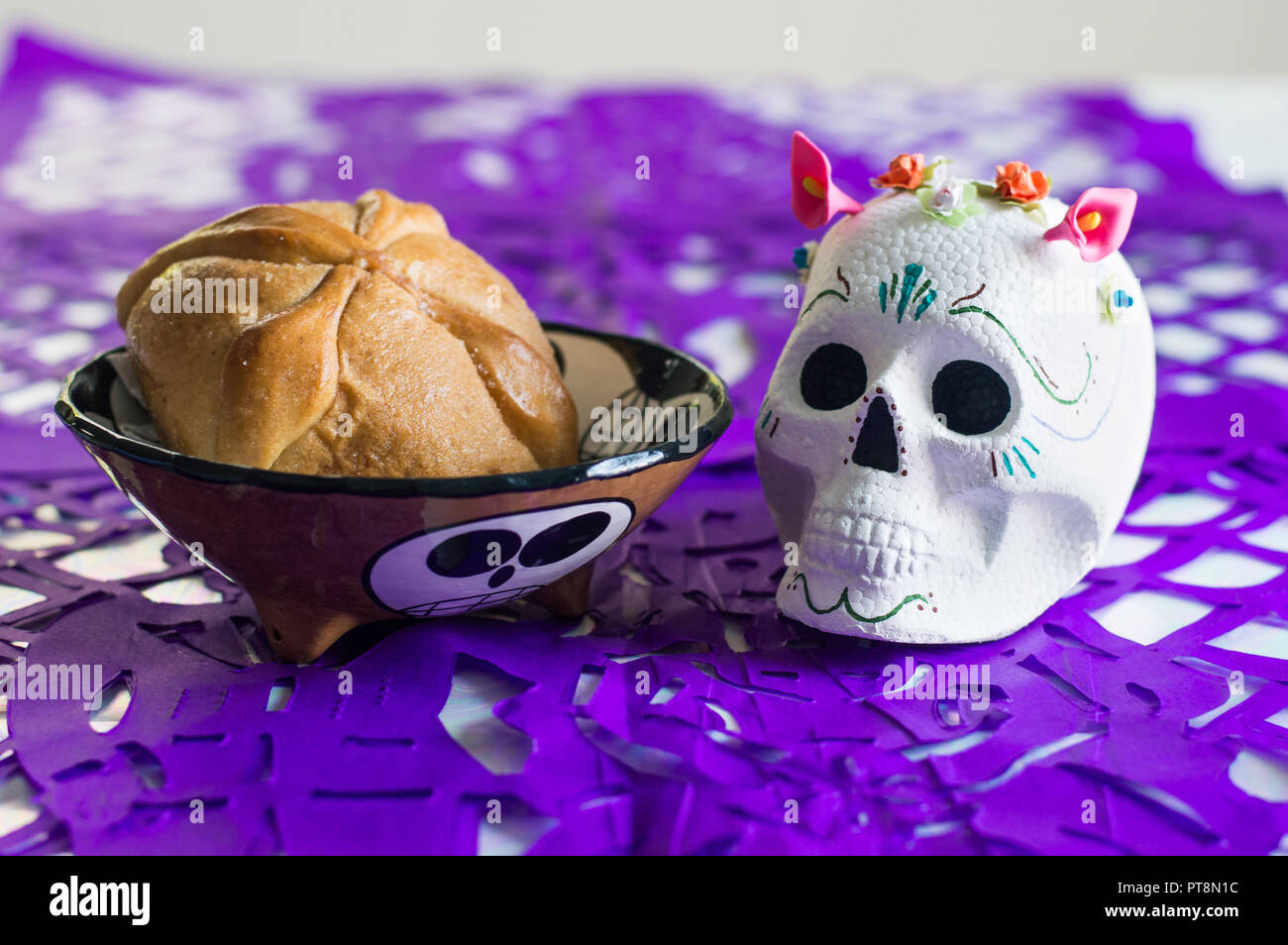 Day of the dead altar, with sugar skull, traditional bread and purple papel picado. Stock Photo